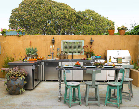 outdoor kitchen with stainless steel appliances and blue wooden chairs